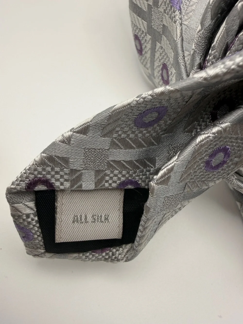 Pierre Cardin tie in a silver and purple geometric pattern. 100% silk.